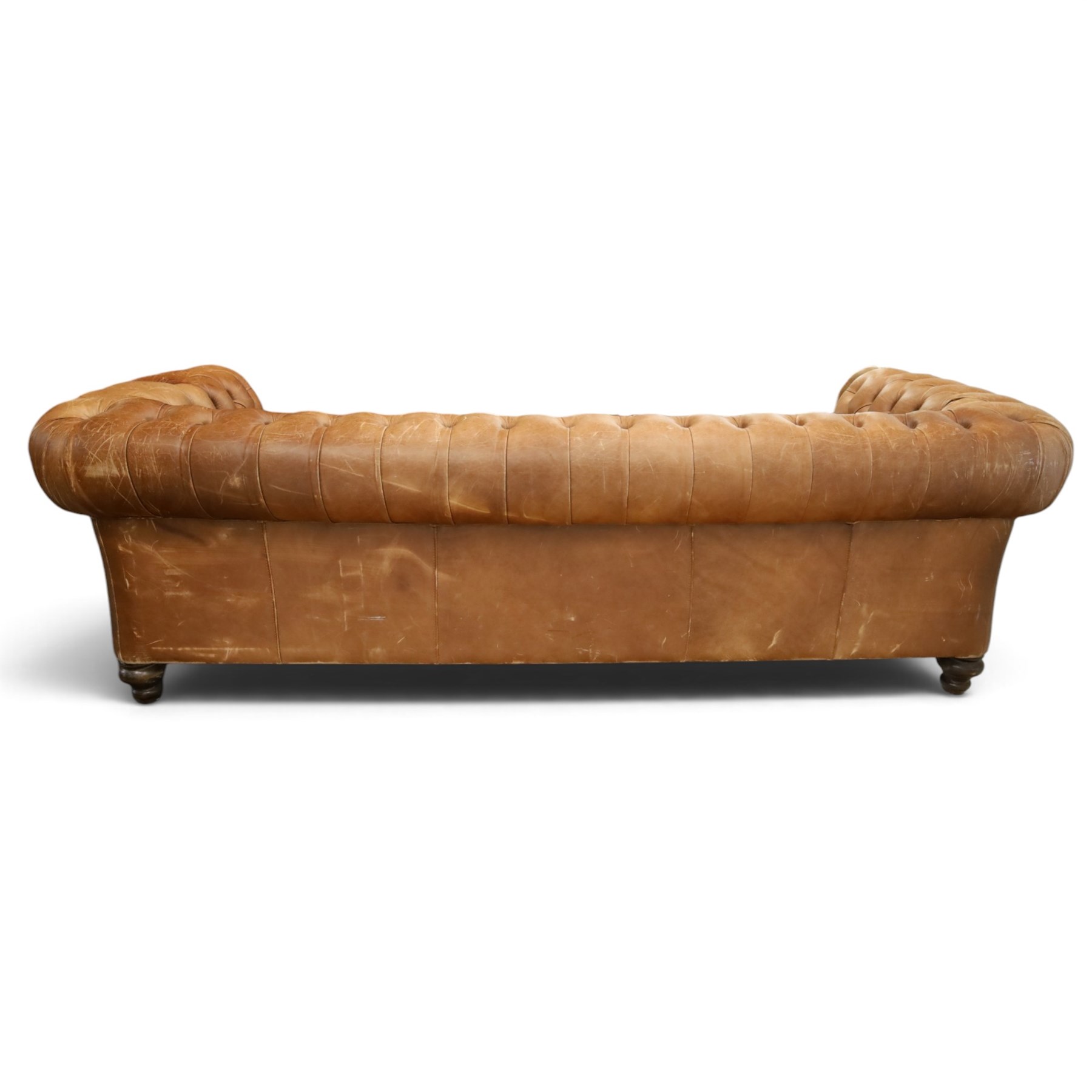 Fleming & Howland Ltd - large traditional shape four seater chesterfield club sofa, the rolled ack and arms with studwork, upholstered in buttoned tan leather with loose seat cushions, raised on large turned feet