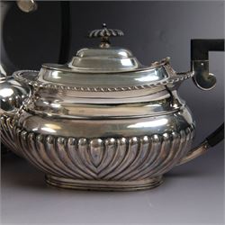 Edwardian silver four piece tea service, comprising coffee pot, teapot, twin handled open sucrier and milk jug, all of oval bellied form, part fluted and with oblique gadrooned rim, with Bakelite type handles and finials to teapot and coffee pot, hallmarked Fordham & Faulkner, Sheffield 1913