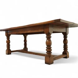 17th century design rustic oak refectory dining table, rectangular plank top over plain frieze rails, raised on heavily turned legs united by an H-stretcher  