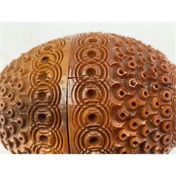Three 19th century coquilla nut pomanders or flea catchers, two of egg shaped form and the third of barrel from with carved and pierced decoration and screw threaded join, largest H8cm