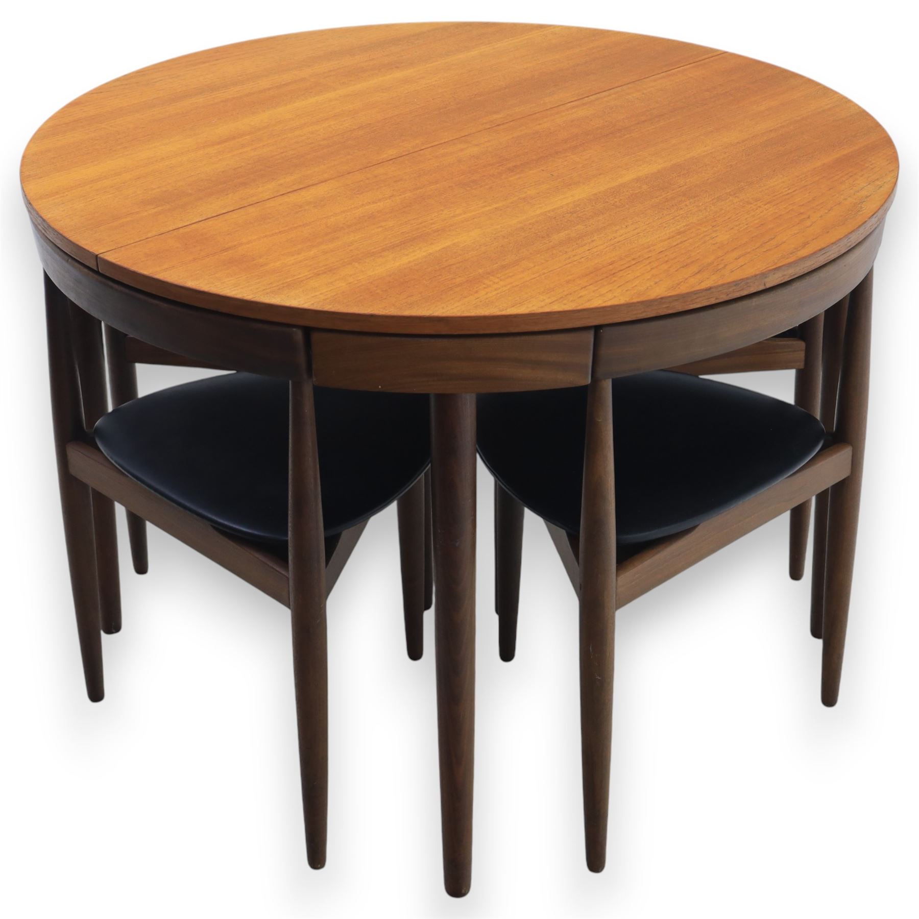 Frem Røjle - Danish teak 'Roundette' extendable dining table, circular top with softly chamfered edge and internal stowable leaf extends to 156cm, raised on four tapered cylindrical legs, accompanied by four matching dining chairs with shaped teak frames and black vinyl upholstered seats, the chairs designed to nest beneath the table when not in use