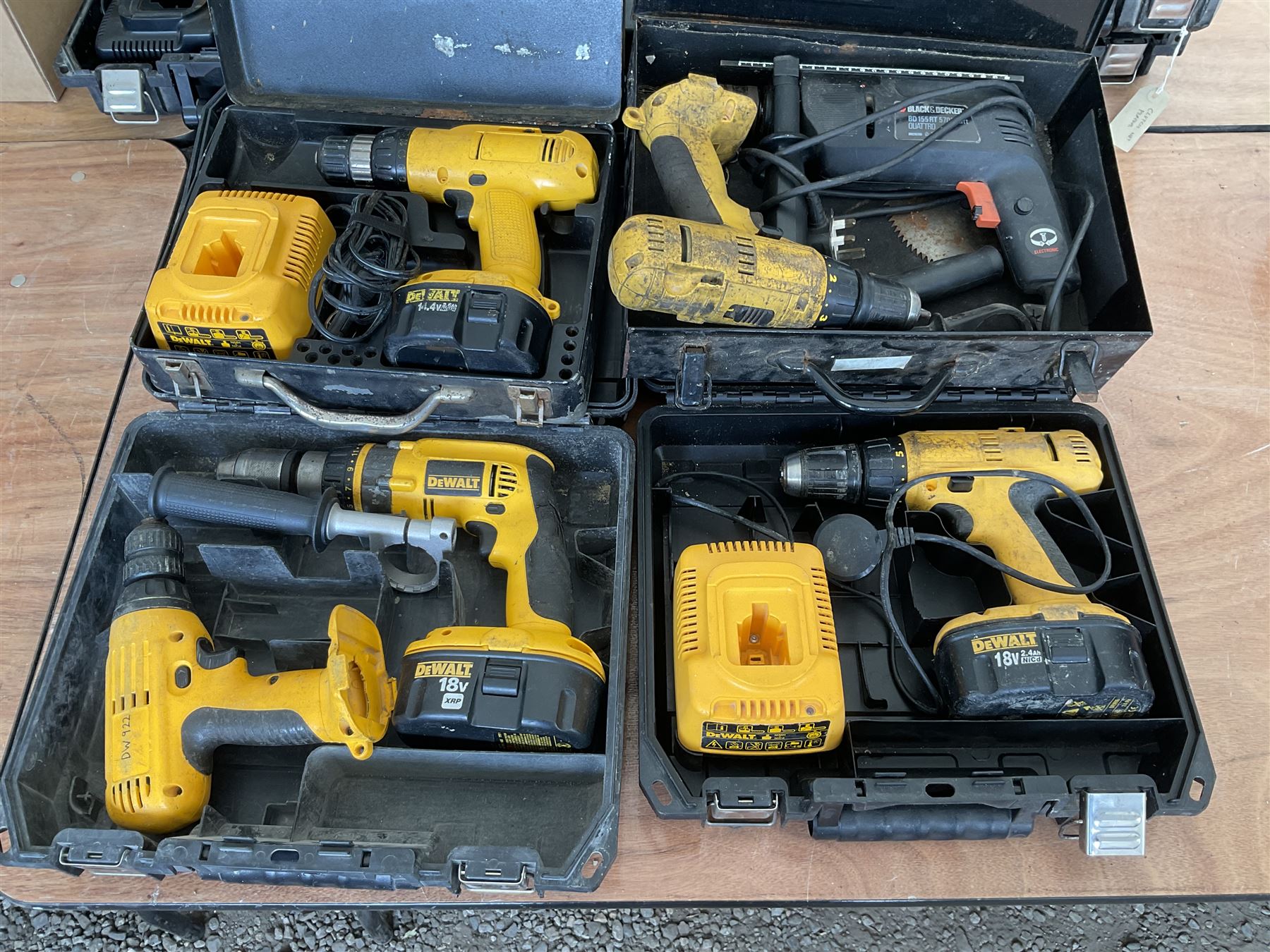 Five DeWalt battery drills with batteries and charger and black and