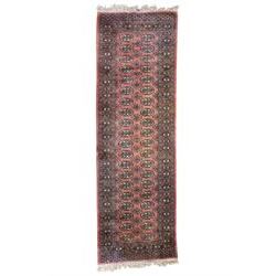 Afghan pale red ground runner, the field decorated with two rows of Gul motifs, within repeating patterned border