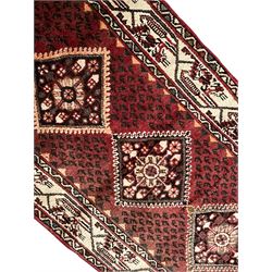 Persian Baluch red ground runner, seven lozenge medallions each decorated with stylised floral motifs, ivory border decorated with trailing pattern and Boteh motifs, within geometric guard stripes 