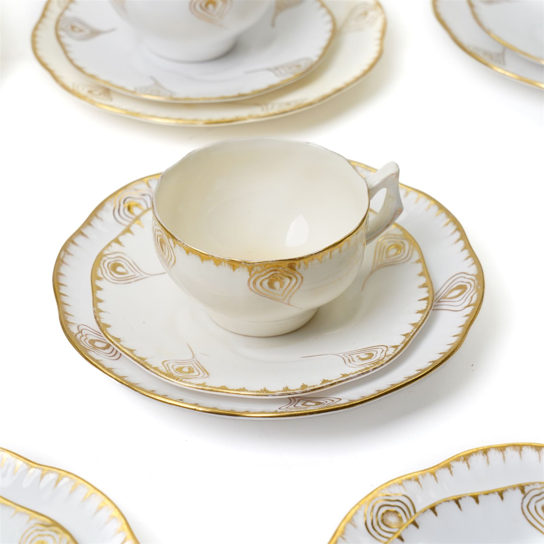 Early 20th century Sarreguemines tea wares, decorated with peacock feathers in gilt, comprising six teacups, eight saucers and eight side plates