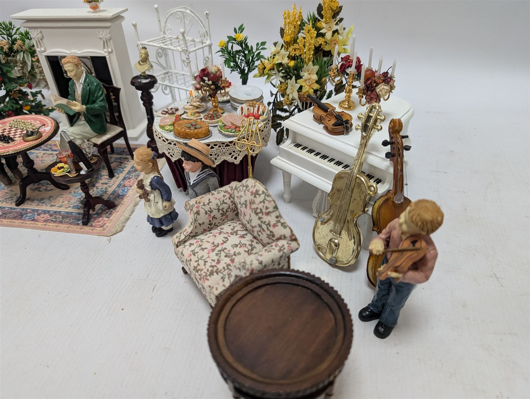 Dolls house furniture, including pianos, fireplace, plants, flower arrangements, tables, chairs, six figures and a collection of instruments and other accessories