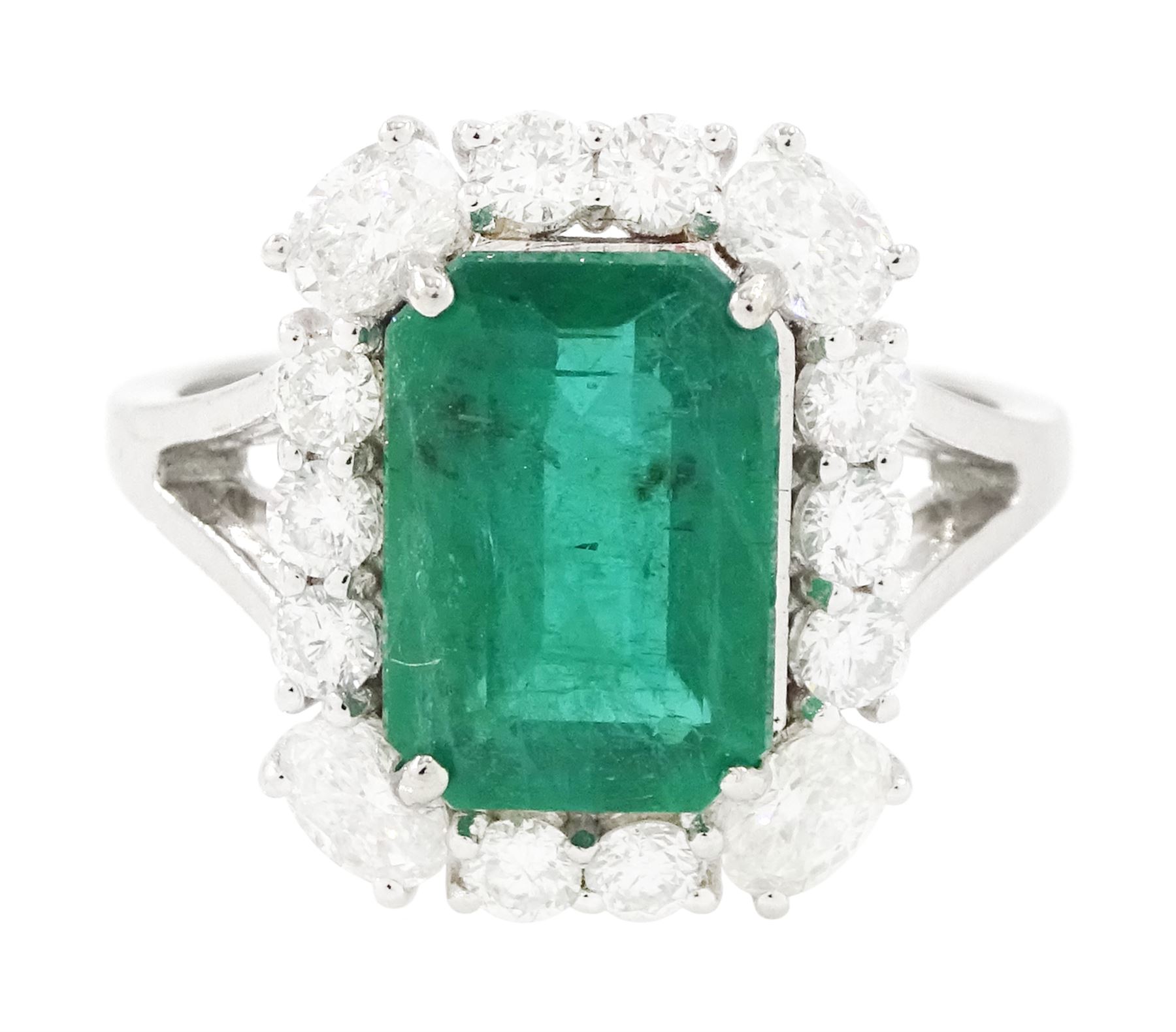18ct white gold emerald and diamond cluster ring, single octagonal cut emerald of approx 2.90 carat, surrounded by twelve round brilliant cut diamonds and four oval cut diamonds to each corner, stamped 18K, total diamond weight approx 0.90 carat