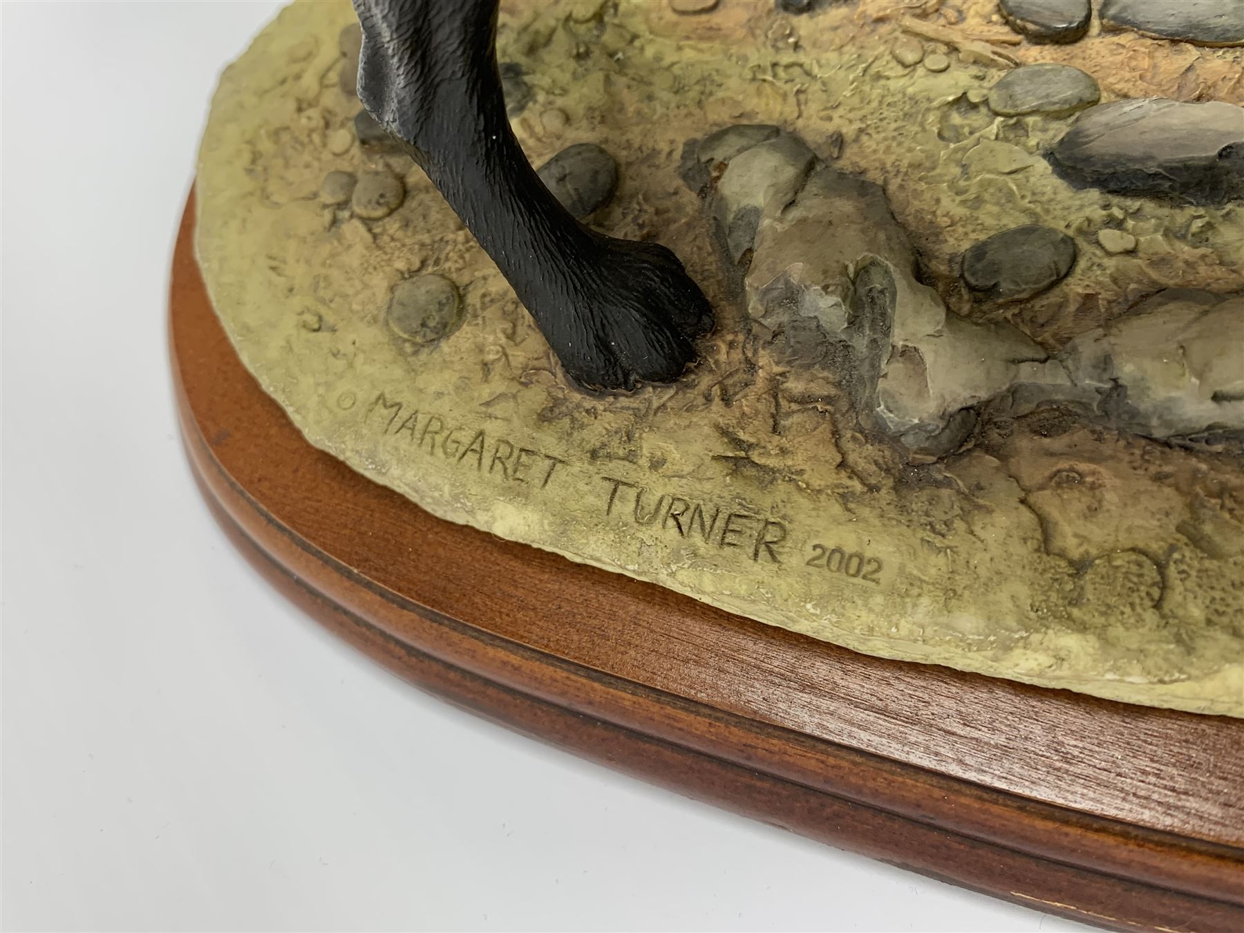 Two Border Fine Arts models, the first example a black Labrador, by Margaret Turner, upon oval wooden base, the second example a Dogs Galore Black Labrador, together with a Sherratt and Simpson model of a black Labrador