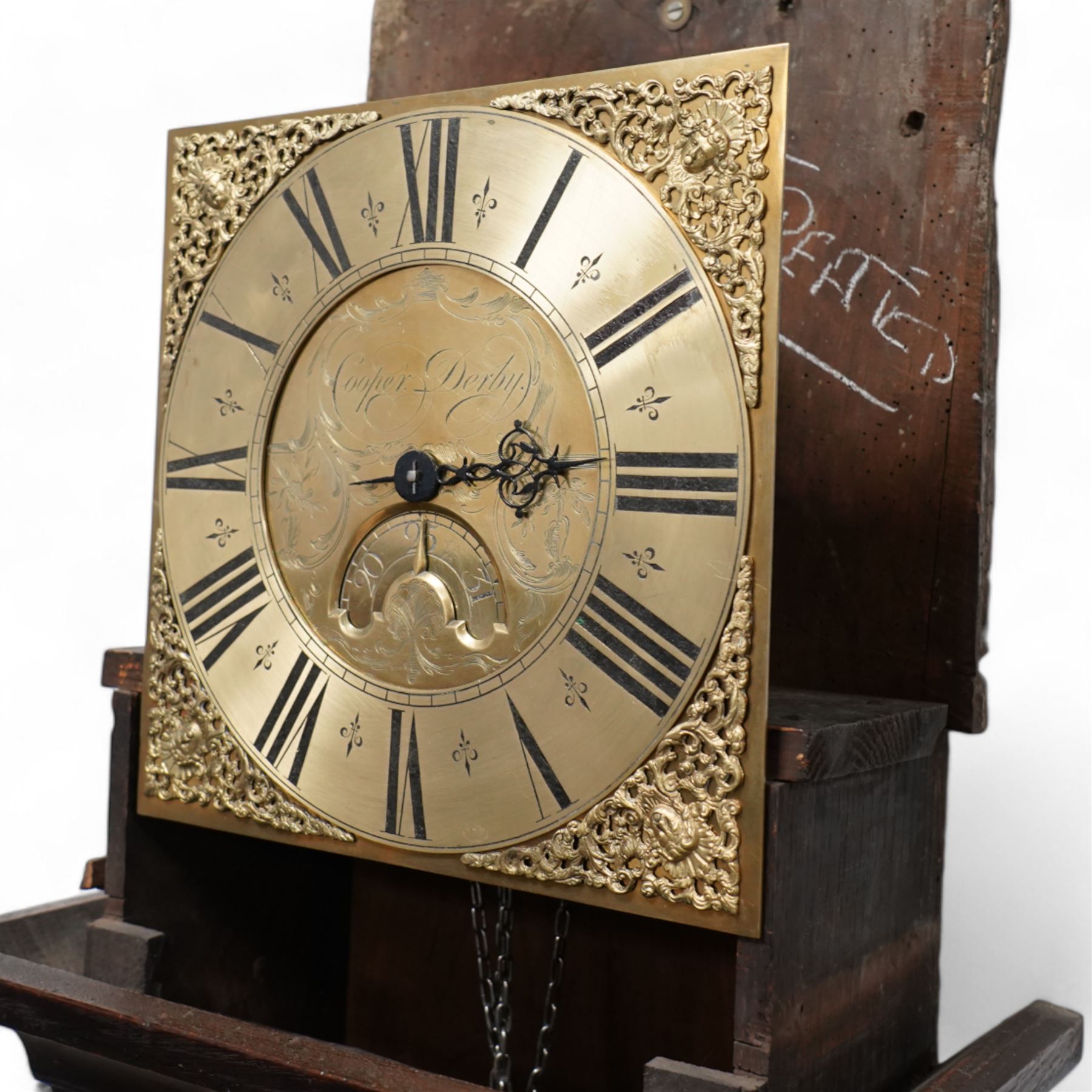 Cooper of Derby - Early 18th century 30hr oak longcase clock c1740, with a flat topped hood and plain frieze beneath, square hood door flanked by turned pilasters with wooden capitals, long trunk door with a wavy top on a square plinth with applied skirting, brass dial with cast spandrels and an engraved dial centre, chapter with Roman numerals, quarter hour markers, single steel hand and date aperture, chain driven countwheel striking movement, sounding the hours on a bell. With weight and pendulum.