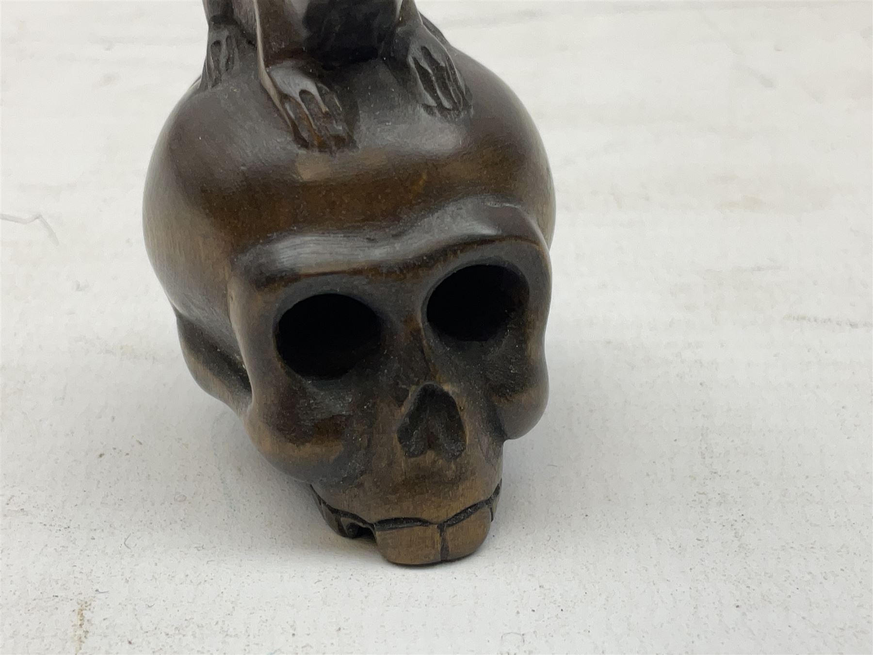 Netsuke in the form of a rat sitting on a skull, signed to the base