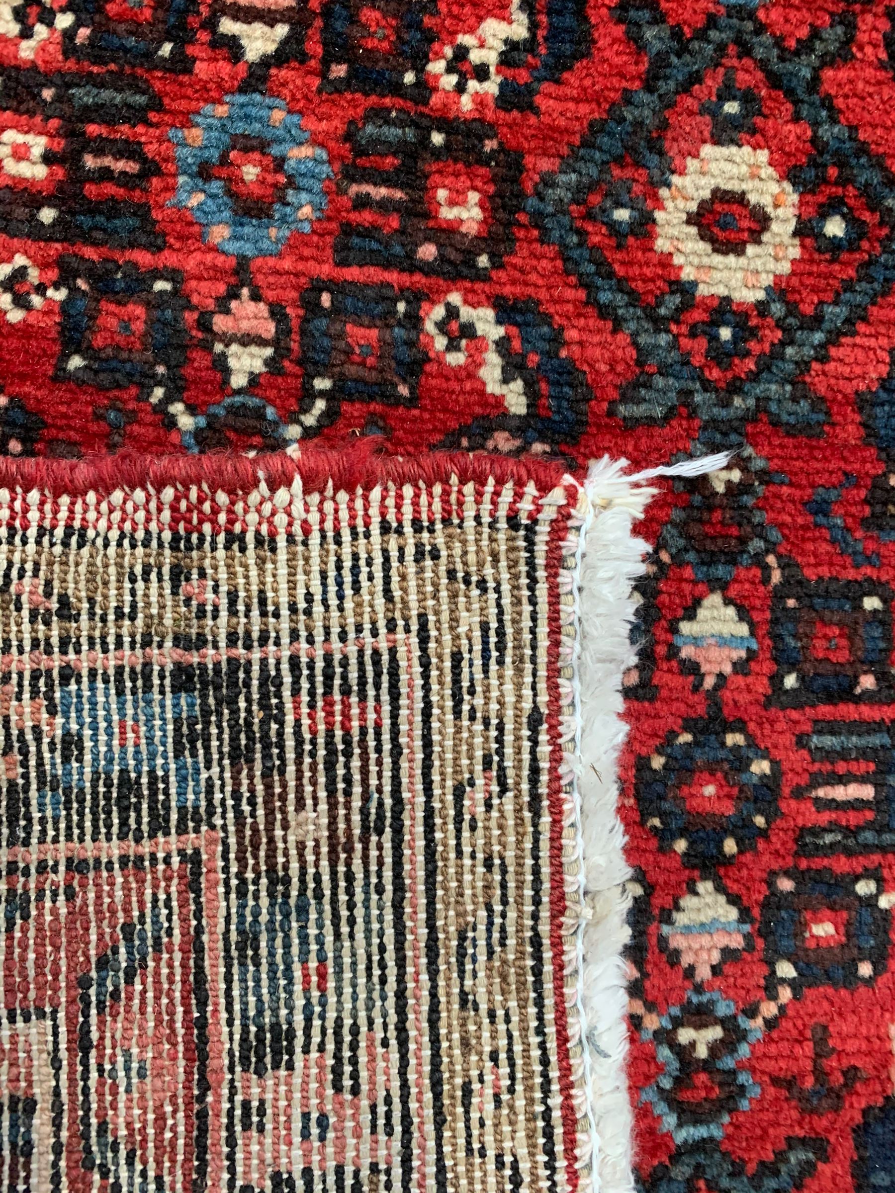 Persian crimson ground runner, the field decorated with Herati motifs,  three-band border, the main band decorated with repeating flowerheads 