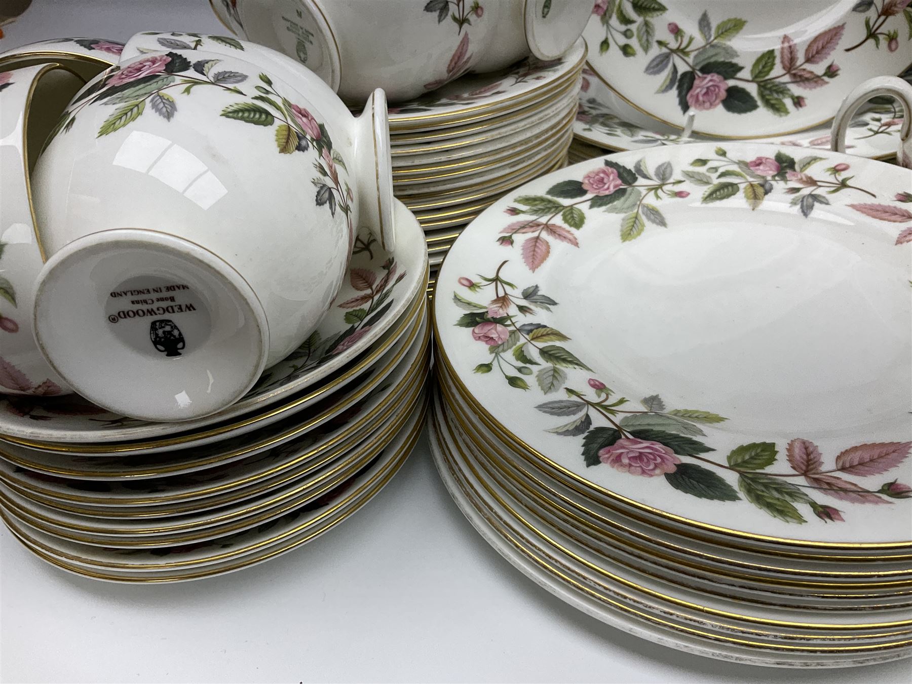 Wedgwood Hathaway Rose pattern tea and dinner wares, comprising twelve saucers, sixteen teacups, twenty tea plates, jug, sucrier, thirteen shallow bowls, sauce boat and saucer, two lidded tureens, larger jug, ten dinner plates, nine smaller plates and two large oval serving dishes