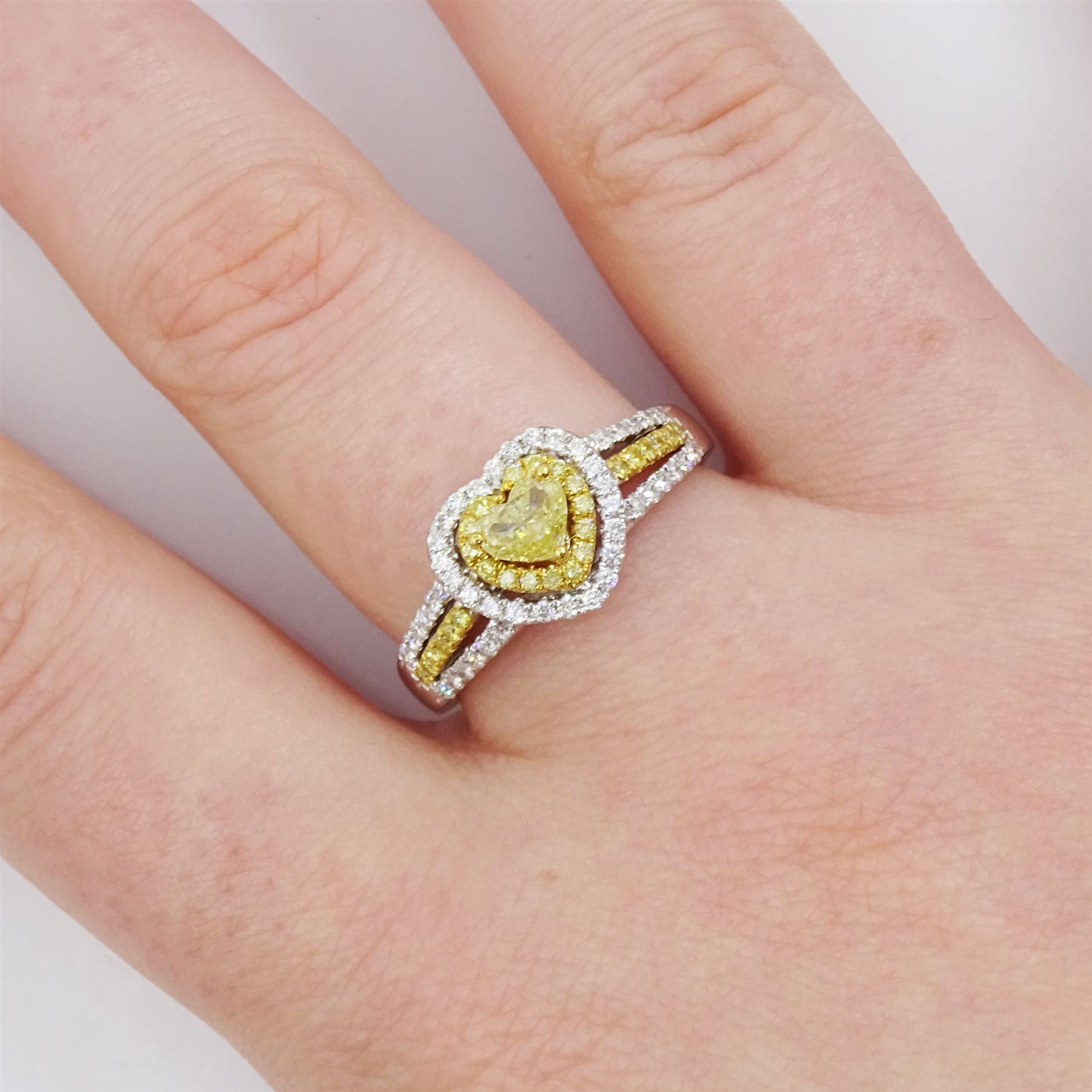 18ct white gold diamond heart cluster ring, principal heart cut fancy yellow diamond of approx 0.25 carat, surrounded by two halos of fancy yellow and white diamonds and split diamond set shoulders, Birmingham 2008, total diamond weight approx 0.50 carat