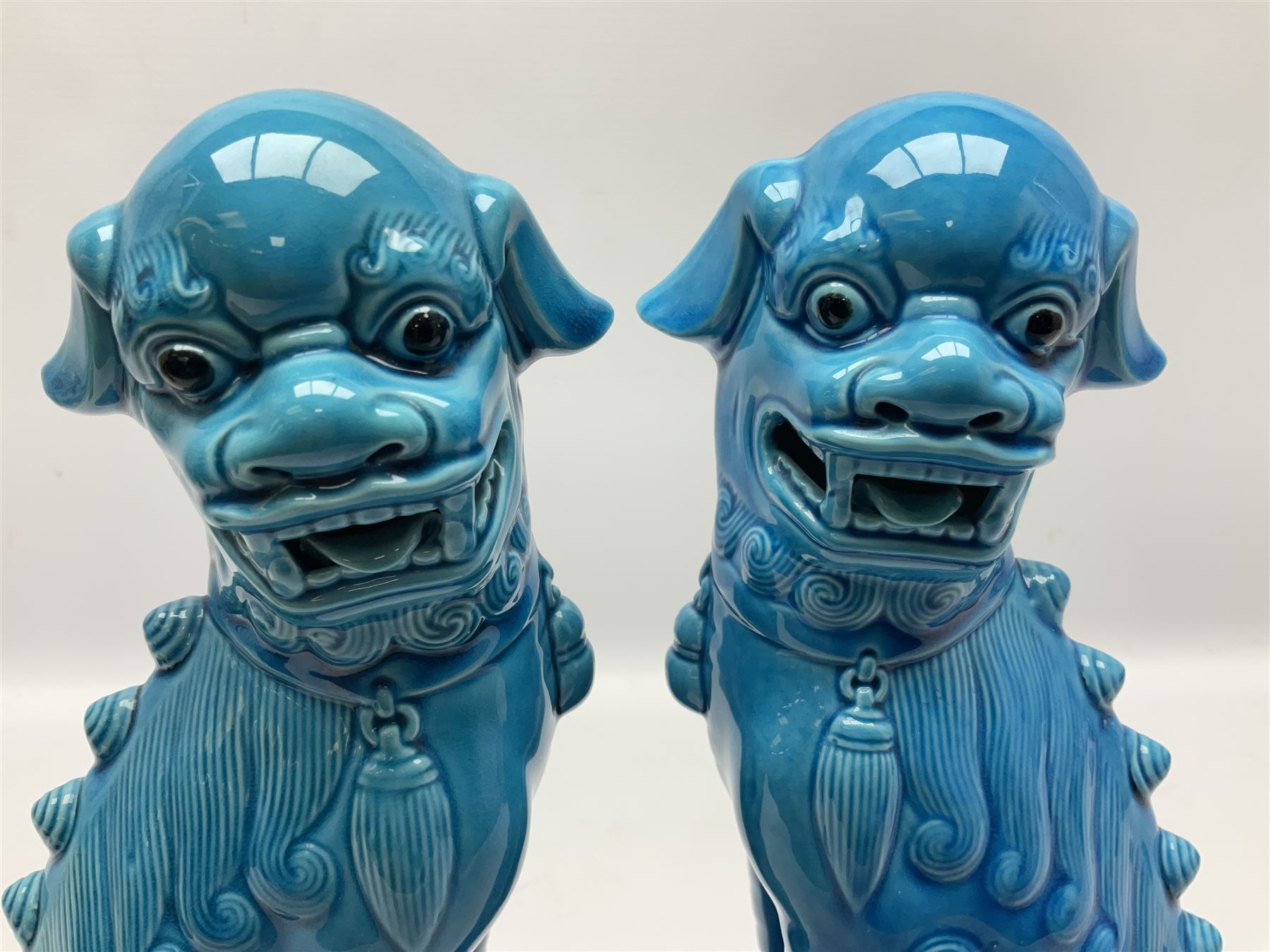 20th century pair of blue glazed Foo Dog statues raised upon a square plinths, together with a