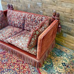 Knole type drop arm sofa with cushions in a traditional patterned upholstery,