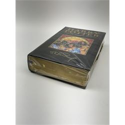First Edition 'Harry Potter and the Deathly Hallows' by J.K. Rowling, partially sealed in plastic wrapper