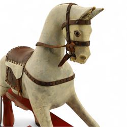 20th century carved and painted rocking horse, with original dappled paint finish, studded leather saddle and reins, on later red and black swing frame