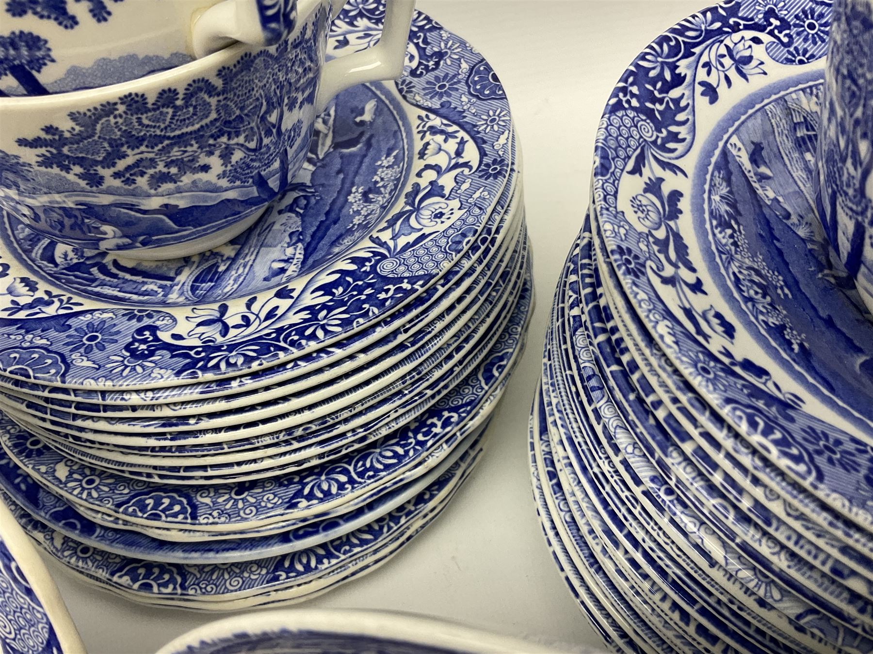 Spode blue and white Italian pattern dinner and tea wares, comprising five dinner plates, four side plates, seventeen side plates, four bowls, ten tea cups and twenty one saucers, five coffee cans and six saucers, and a flan dish, with blue and black printed marks beneath 