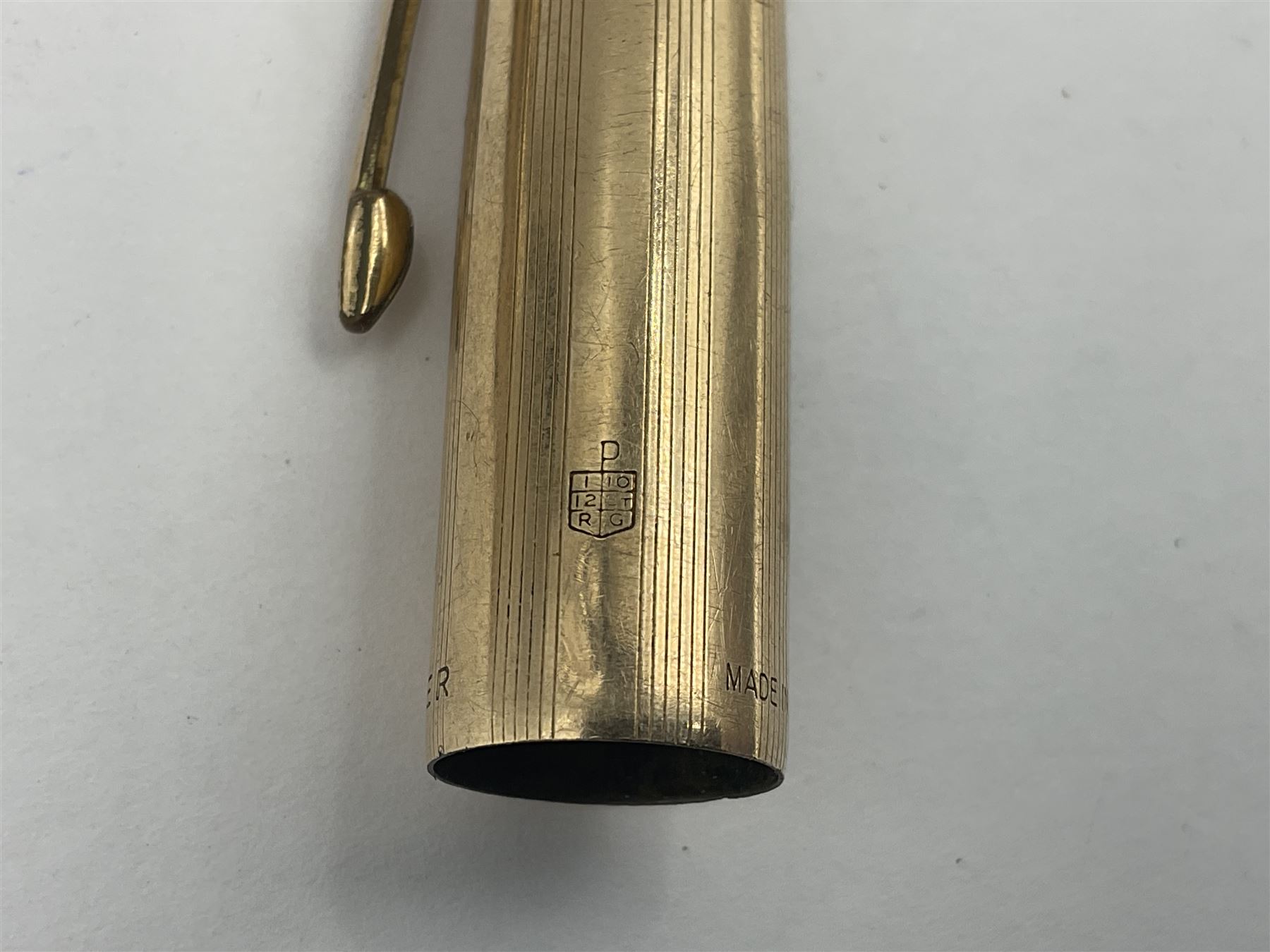 Three rolled gold Parker fountain pens, comprising an example with a gold nib marked 14K 585 and barrel with a shell stamp, a Parker 61 fountain pen with inset gold arrow to the nib, and another similar, all with striated decoration and arrow clips to the caps, L13cm, one with box