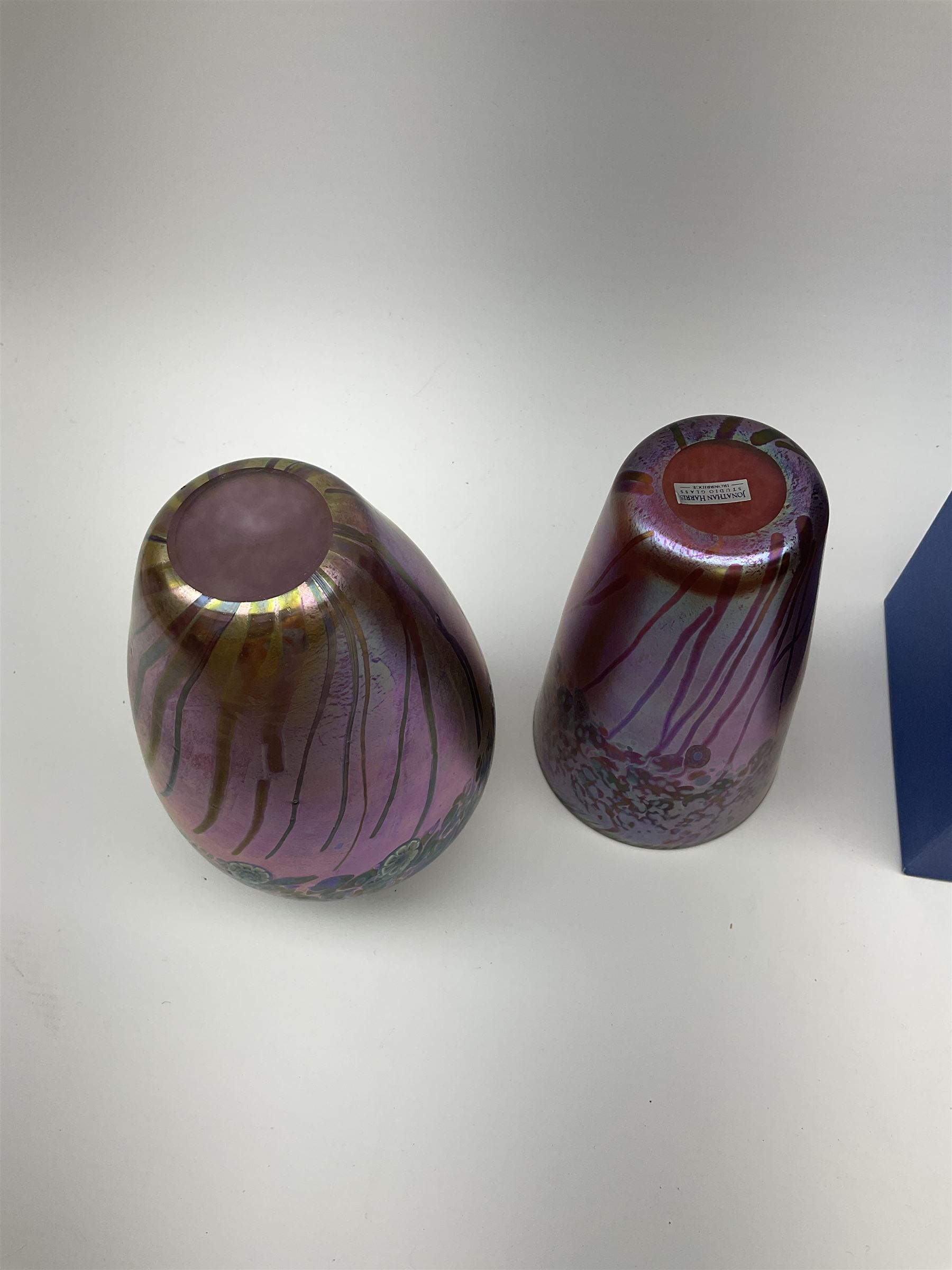 Two Art Glass Jonathan Harris vases, The first example of a baluster form, the second example of tapering cylindrical form,  each with iridescent decoration in tones of purple and blue, tallest example H18.5cm, each with makers box, together with a Isle of Wight glass paperweight. 