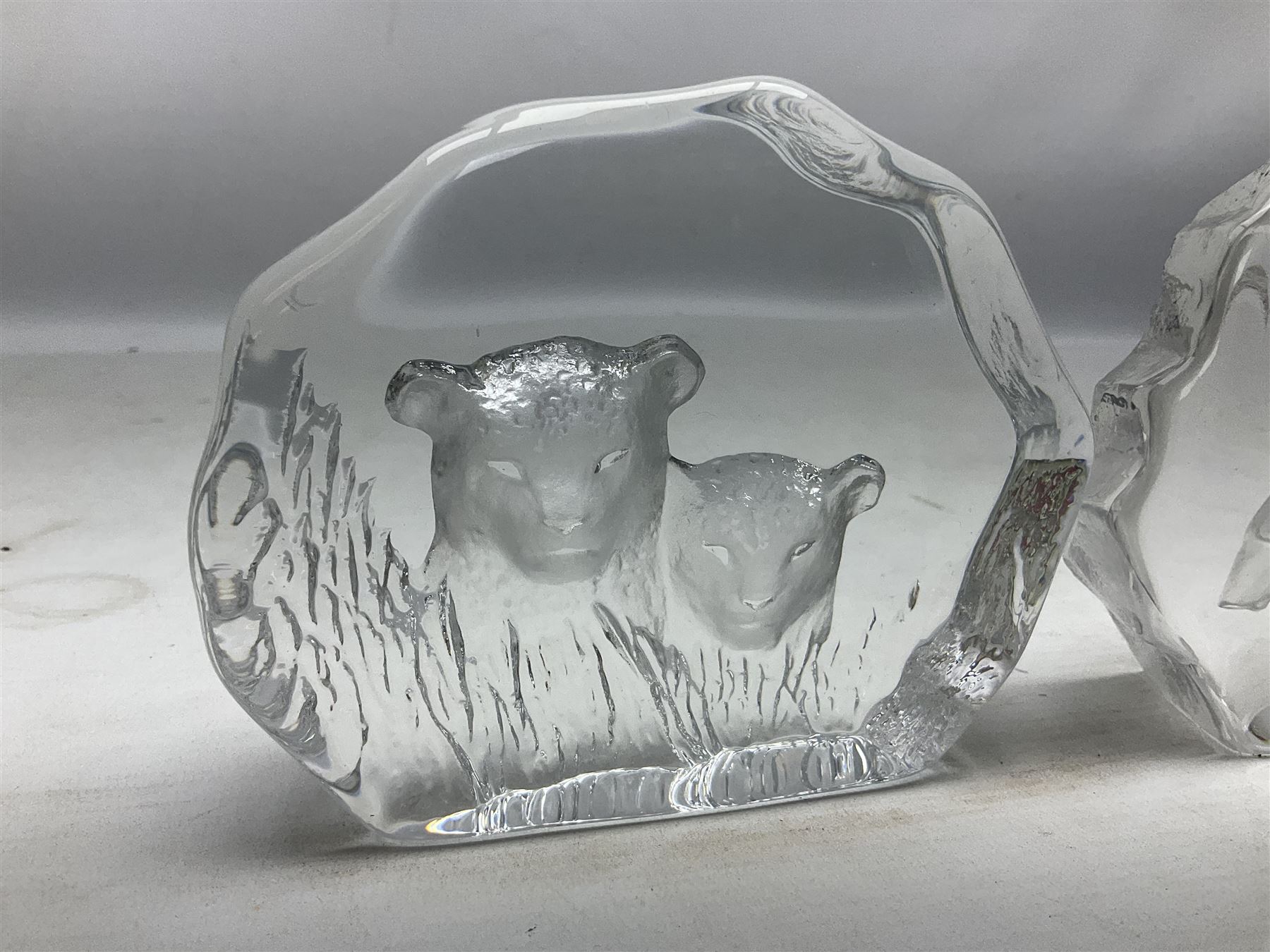 Two Mats Jonasson, Sweden paperweights, comprising polar bear in ice cave no 3152 and lion cubs, both with etched marks beneath, tallest H11.5cm