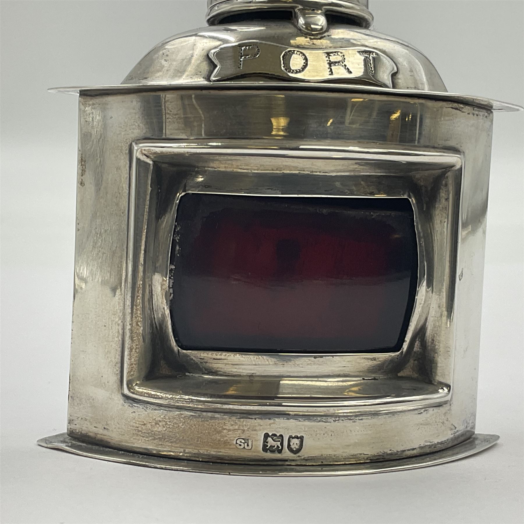 Early 20th century silver novelty inkwell, modelled as a ship's port lantern, with swing handle, convex red glass panel and hinged cover opening to reveal a glass liner, hallmarked Samuel Jacob, London 1911, height not including handle H8.5cm