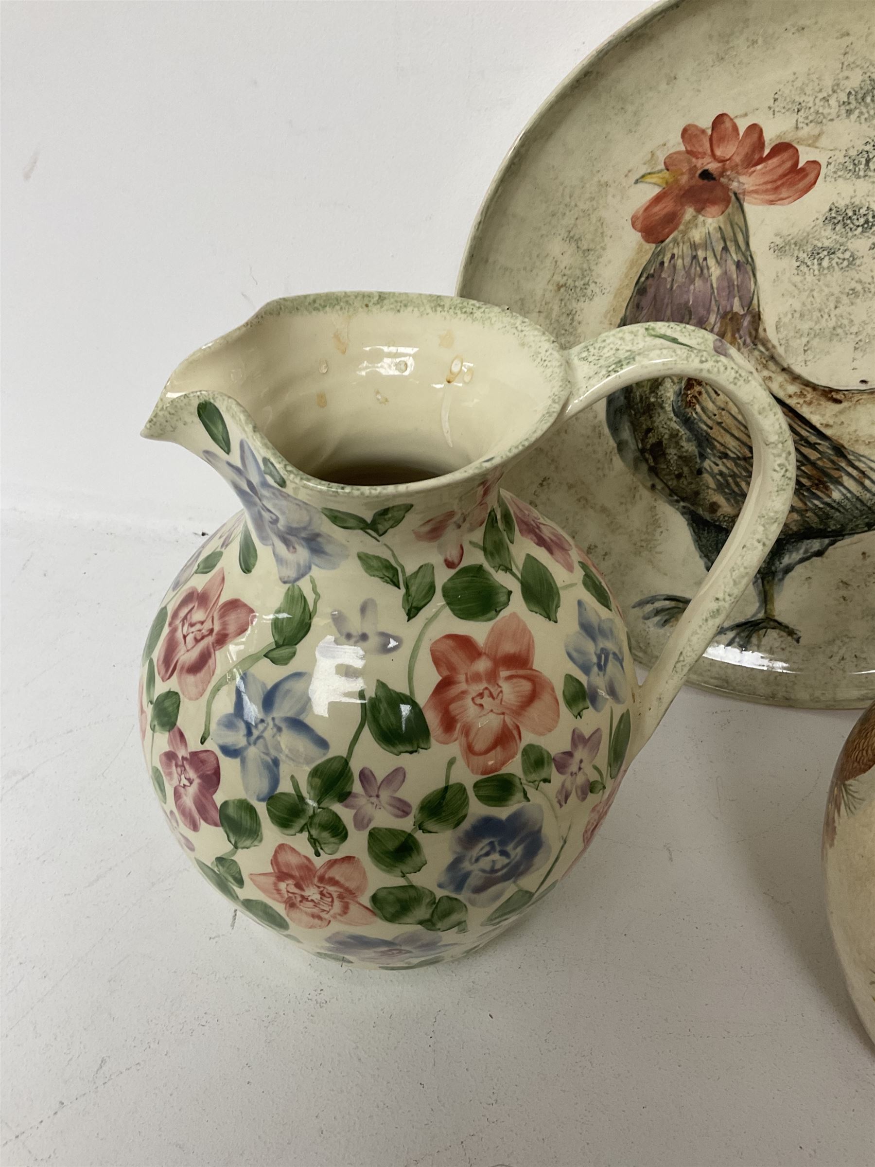 Collection of Yorkshire Moorlands Pottery, comprising two large circular dishes and three jugs, decorated with various fish, flowers, red grouse and cockerel