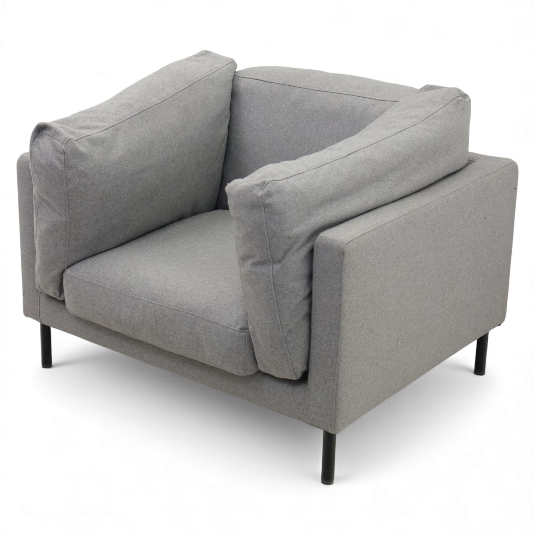 Modern snuggler armchair, upholstered in grey fabric, box-shaped frame with loose back and side cushions, raised on slender black metal legs