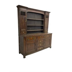 George III oak dresser, projecting cornice over three tier plate rack flanked by reeded uprights and two cupboards, enclosed by slatted and panelled doors above small drawers, the lower section fitted with six drawers and two cupboards, on bracket feet