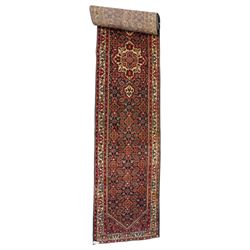 North-west Persian Malayer runner rug, the indigo ground decorated with ivory medallions a...