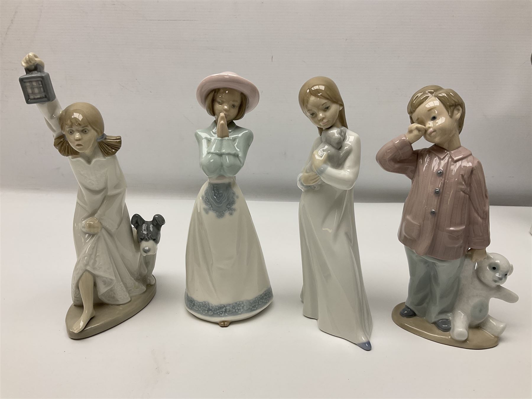 Eleven Nao figures to include Cowboy, Girl with Puppy, Clown, Girl in hat etc 