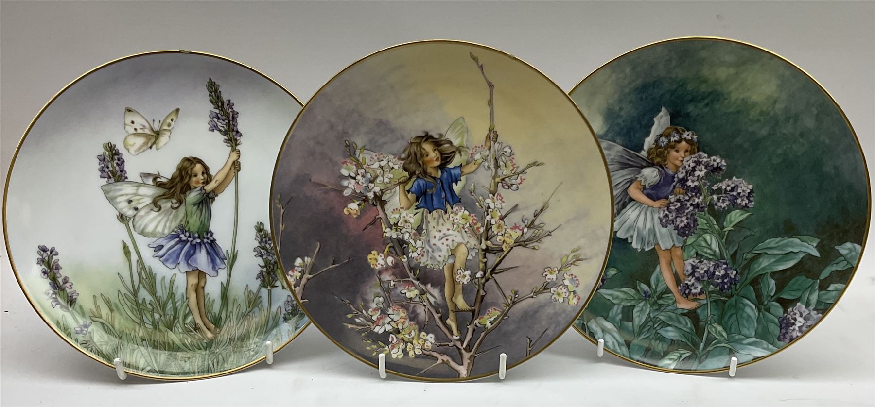 Four Royal Doulton Images figures comprising 'Happy Anniversary', 'Wedding Day', 'Congratulations' and 'Carefree', together with a set of three Heinrich collectors plates depicting Fairies.
