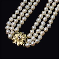 Three strand cultured white / cream pearl necklace, with an 18ct gold diamond set leaf design clasp