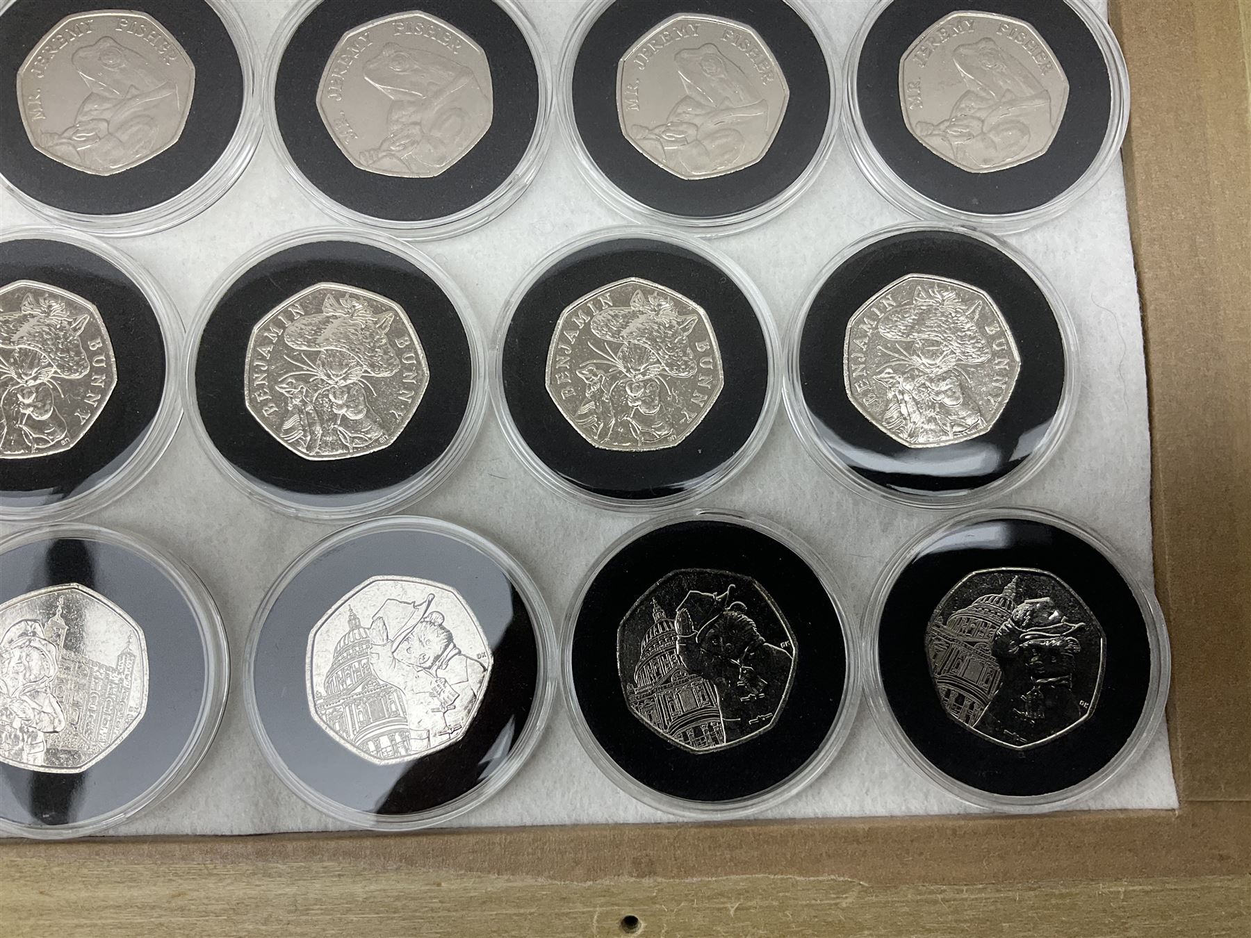 Thirty-seven commemorative fifty pence coins, including 2011 wrestling, other Olympics, Beatrix Potter etc, housed in capsules