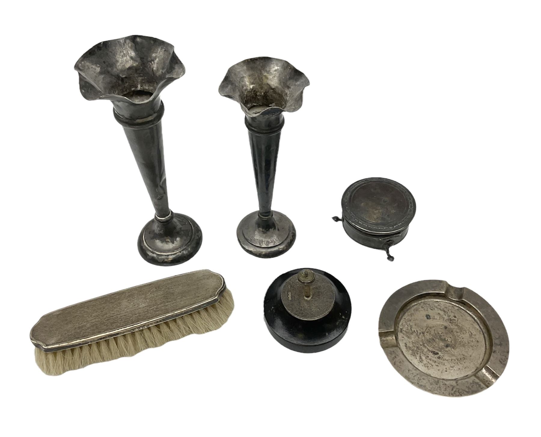 Two early 20th century silver trumpet vases to include a Martin Hall & Co Ltd example, silver circular box raised on three feet stamped Birmingham 1912, ashtray hallmarked London 1945, silver backed hair brush with engine turned decoration etc, tallest H19.5cm