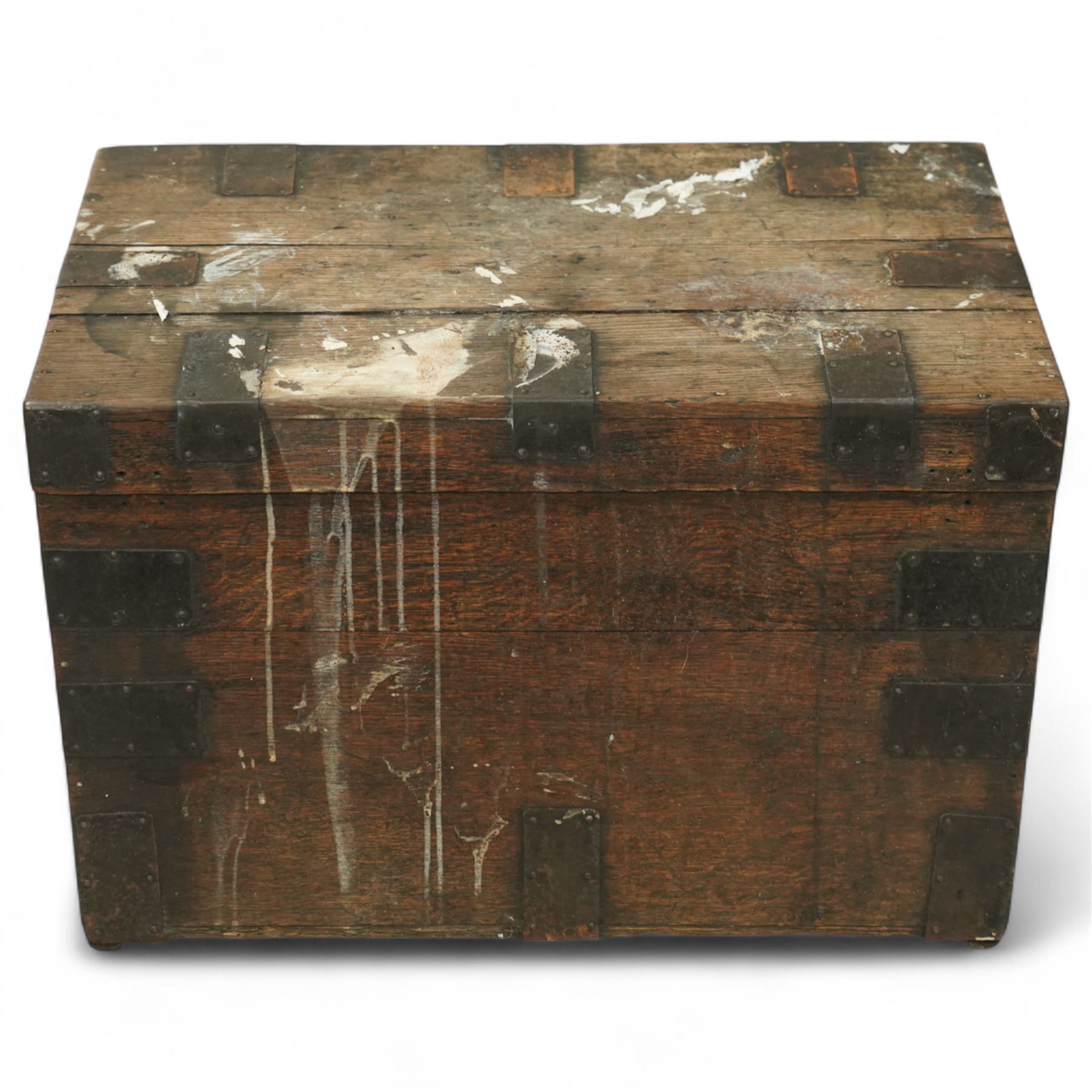 19th century metal bound ship’s trunk, of trapezoidal form with hinged lid, iron strapwork and corner reinforcements, remains of paper lining to interior