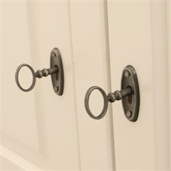 Modern white painted double wardrobe, fitted with two panelled doors, enclosing a hanging rail and shelving, raised on bracket feet