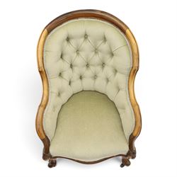 Victorian carved walnut framed armchair with matching stool, the tub-shaped chair with moulded and shaped frame and arm terminals, raised on scrolled cartouche carved supports with scroll feet and castors, buttoned back and sprung seat upholstered in sage green fabric; the small circular footstool with buttoned seat and scroll supports (W36cm H15cm)