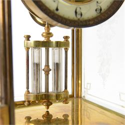 French- Art-deco Edwardian 8-day four-glass clock garniture, with etched glass panels, cast brass decoration to the corners of the case and splayed feet representing cloven hoofs to the base, case surmounted by a large oval urn on a tiered brass platform, two part dial with a recessed brass centre comprising of pierced radial decoration, with steel spade hands and Arabic numerals to the chapter, rack striking movement with a deadbeat Brocot escapement, striking the hours and half-hours on a bell. With a visible twin file mercury pendulum. Garni comprising two large twin handled urns on rectangular pedestals raised on conforming feet representing cloven hoofs, Clock and garni presented on three shaped wooden gesso bases with velvet pads. With key.