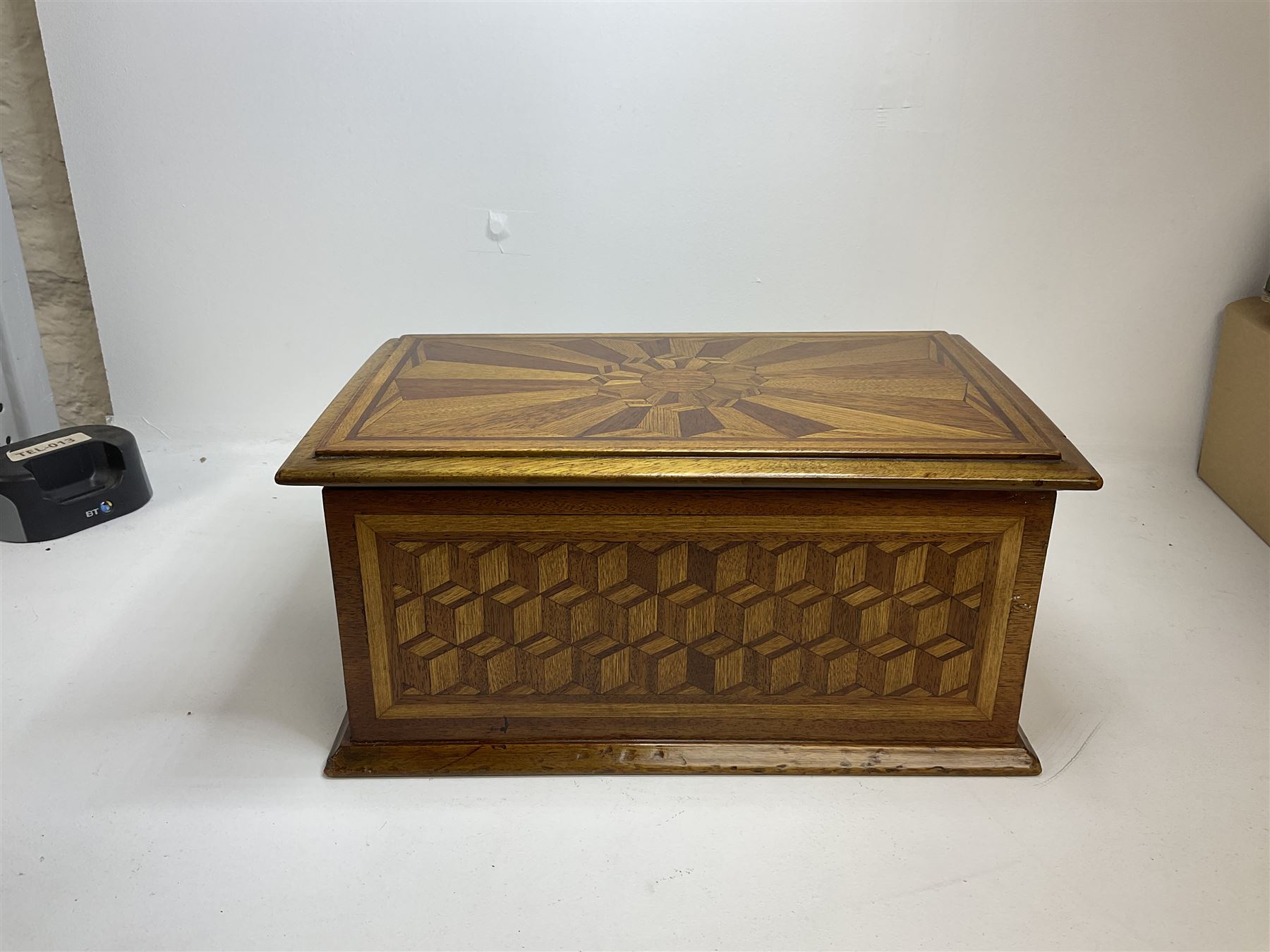 19th Century mahogany and parquetry box of rectangular form, geometric cube design, with a stylised sun detail to the hinged cover, opening to reveal three compartments, L33cm D21cm H16cm
