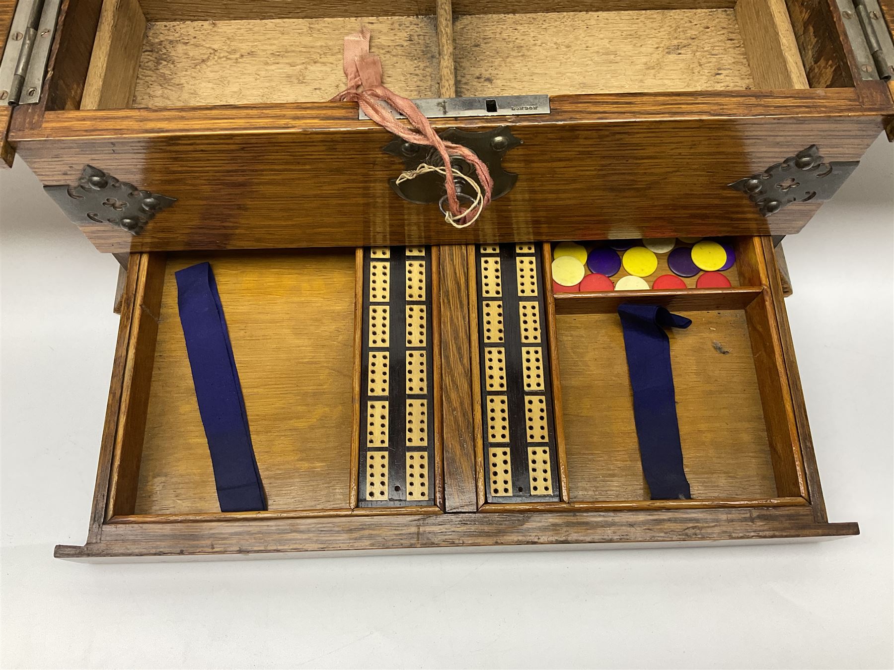 Victorian oak tantalus, mirrored high-back with recess for housing the decanters, behind a hinged box, with cribbage board to the concealed drawer below, marked Barman, London, H33cm, L37cm