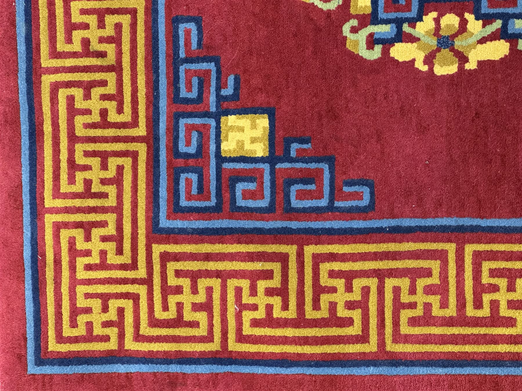 Tibetan-design handwoven rug, deep red field with three central medallions in yellow and blue, traditional yellow key border, white fringes on both ends