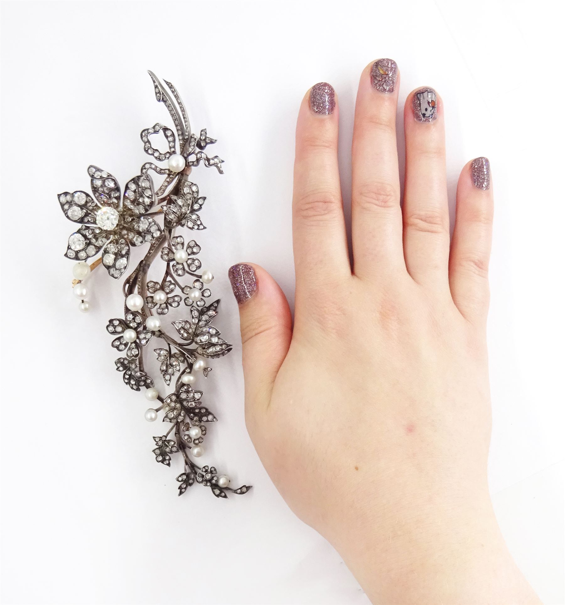 19th century gold and silver diamond and pearl en tremblant detachable brooch, the flower tremblant with a principal old cut diamond of approx 1.90 carat, the petals and stamen set with old cut and rose cut diamonds, total diamond weight approx 9.10 carat, to a foliate spray set set with further rose cut diamond and white / pink / cream pearls and ribbon tie