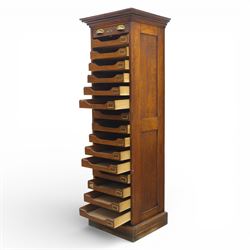 Edwardian oak pedestal office cabinet, moulded rectangular top over tambour shutter enclosing fitted interior, with fifteen graduated drawers each with recessed brass cup handle and label holders, panelled sides, on plinth base