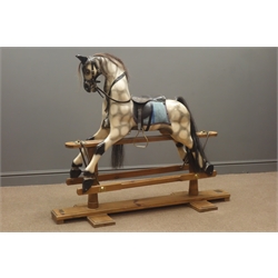  Victorian style wooden rocking horse by The Worcestershire Rocking Horse Company, named Elle, with painted and dappled carved sectional body, horsehair mane and tail, leather bridle and saddle with brass stirrups, and forward and backward action on stripped pine refectory style base W135cm H113cm  