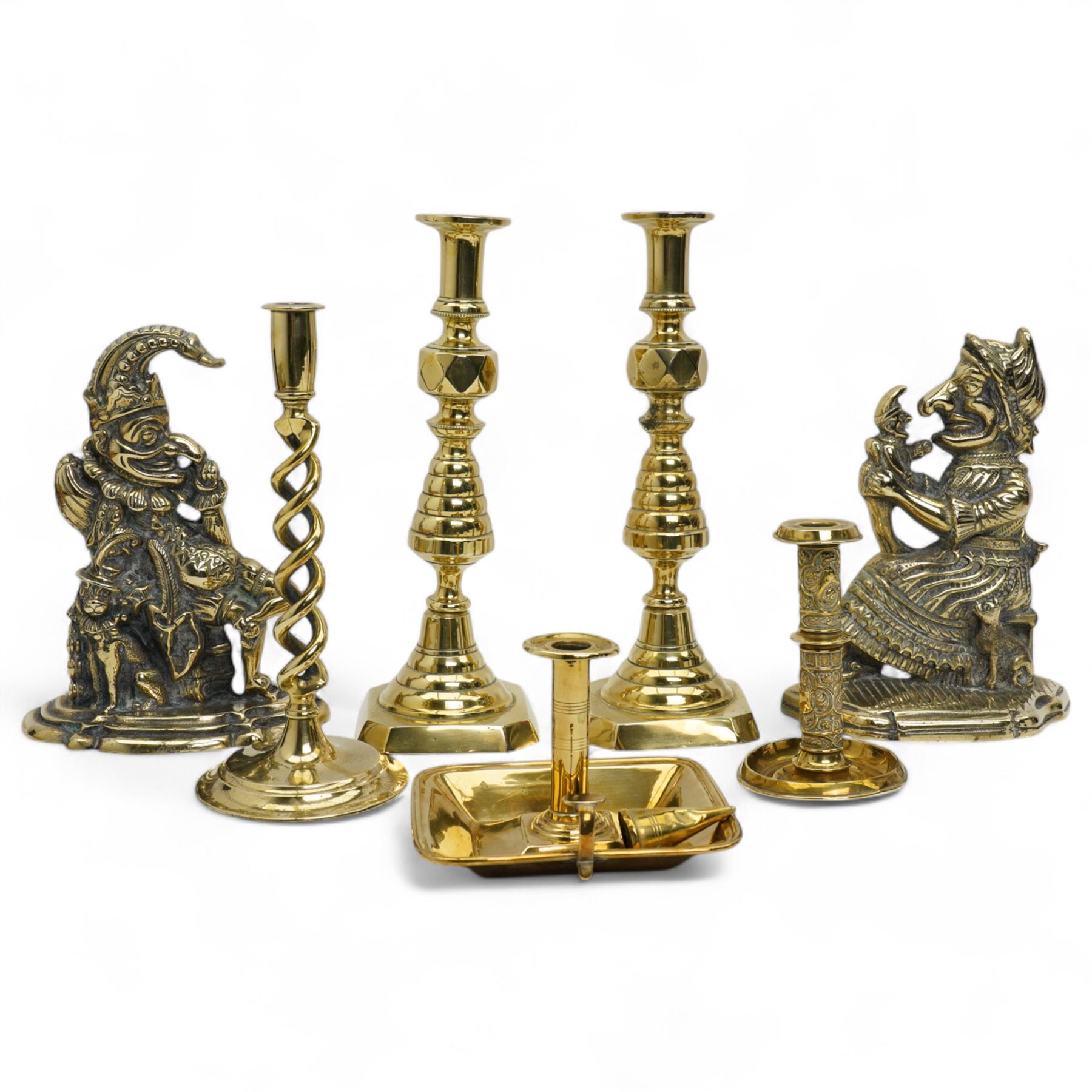 Early 20th century brass 'Mr Punch' doorstop H29cm, another 'Judy' H28cm, pair of brass Jack of Diamonds brass candlesticks H36cm, two other candlesticks and a chamber stick (7)