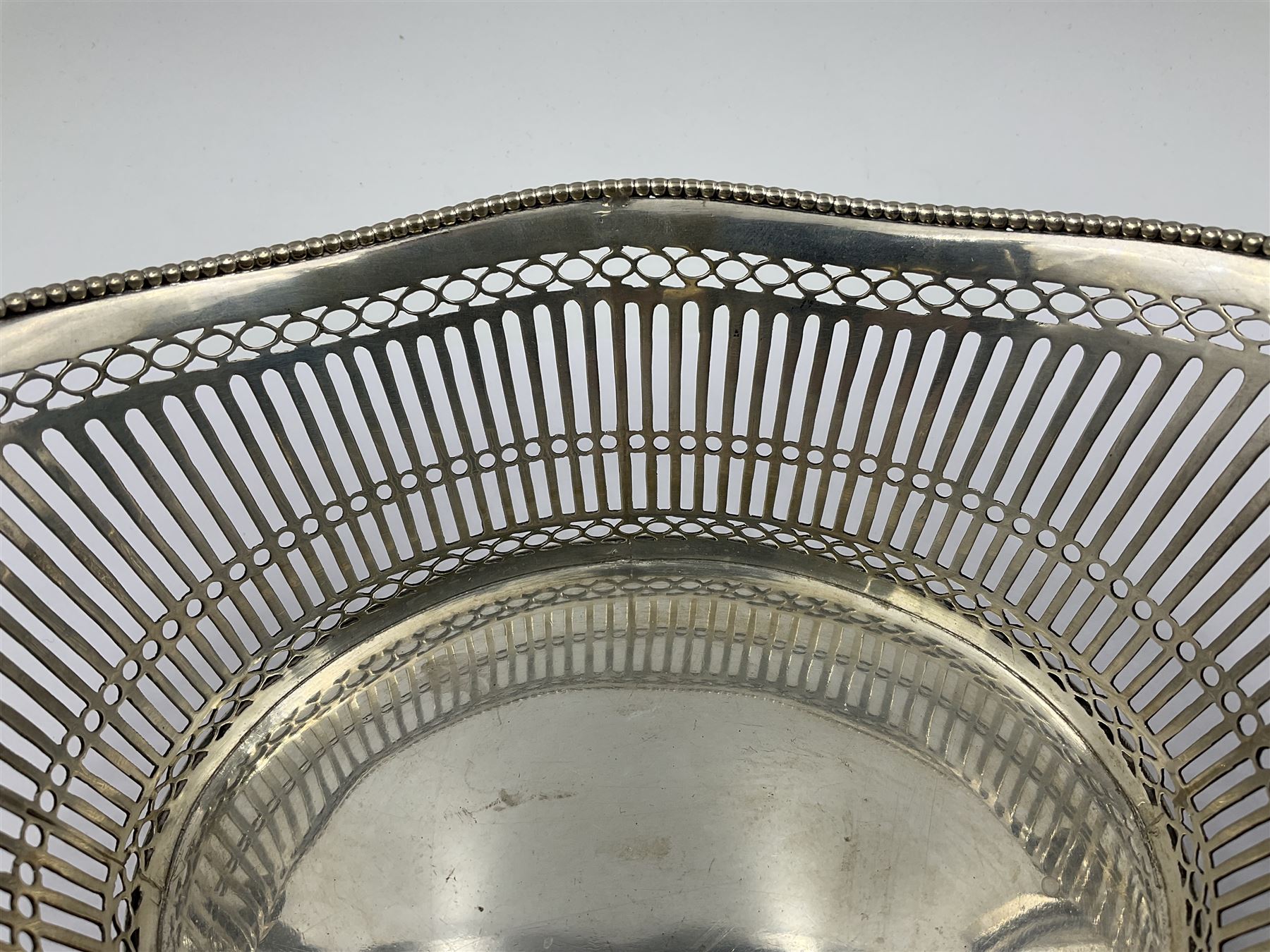 Early 20th century Dutch silver basket, of oval form with pierced sides, beaded rim, and twin handles, marked with Lion Passant for 2nd standard purity and date letter for 1910, other marks worn and indistinct, including handles H8.5cm L25.5cm