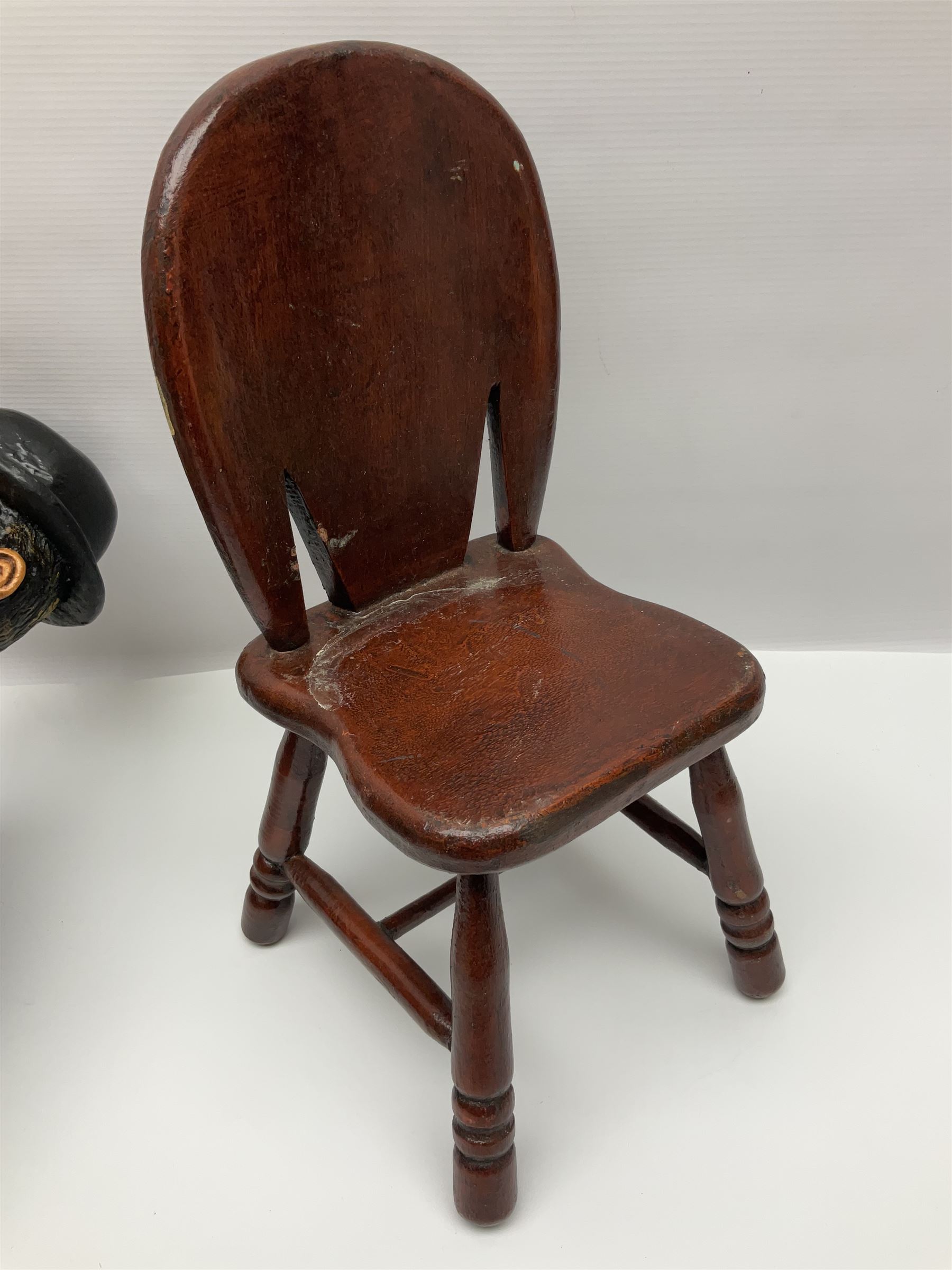 Large painted composite figure of Charlie Chaplin, seated upon wooden chair, H54cm