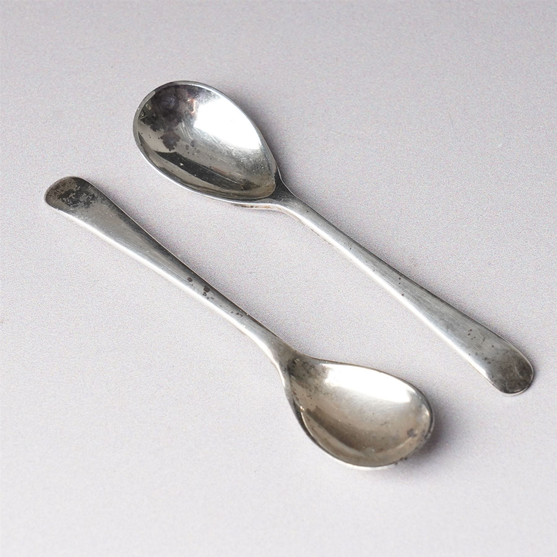 Pair of late Victorian silver salts of oval panel sided design with scroll handles and shaped supports Birmingham 1899 Maker Henry Matthews and two later silver salt spoons 