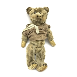 Early 20th century plush covered straw filled teddy bear, the revolving head with boot button eyes and traces of stitched nose and mouth on body with jointed limbs H42cm